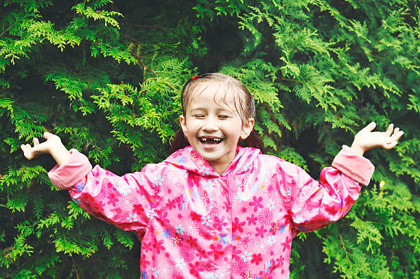 Poco Chica disfrutando de sol después de la lluvia. - foto de stock