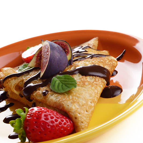 istock Strawberry crepes with chocolate syrup and figs over white close 453451865