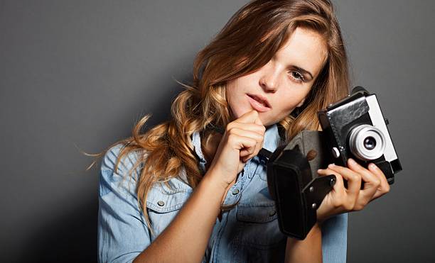 istock Thinking photographer woman with old camera 453461063