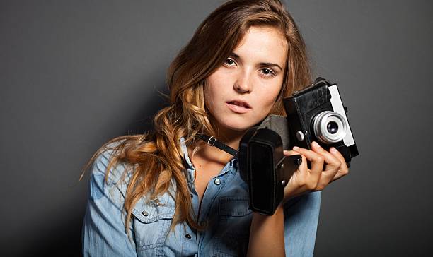 istock Thinking photographer woman with old camera 453462381