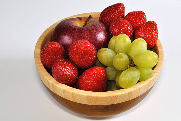 istock Apple with grapes and strawberries in wooden dish 453467231