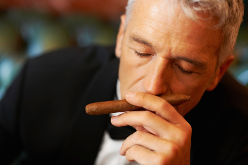 Rich man smelling cigar