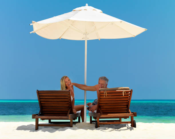 istock Mature couple resting on beach chairs smiling 453468717