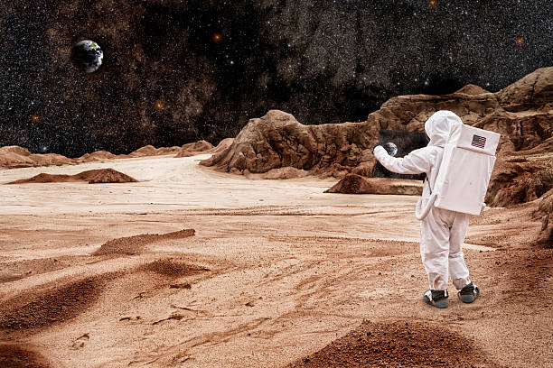 астронавт, изучая карту на mars или the moon - alien world стоковые фото и изображения