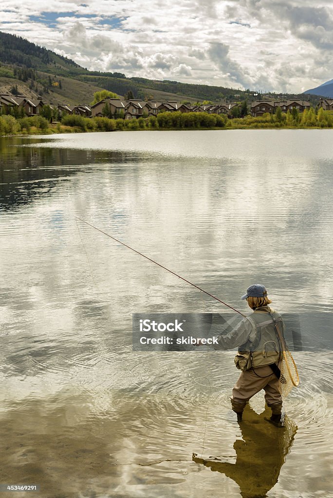 Mulher pesca em um lago - Foto de stock de Pescaria com Iscas Artificiais royalty-free