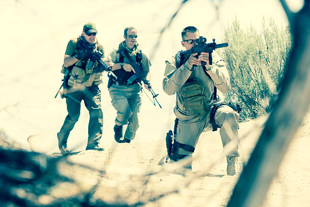 istock Military soldiers doing training exercises with weapons in desert 453469349