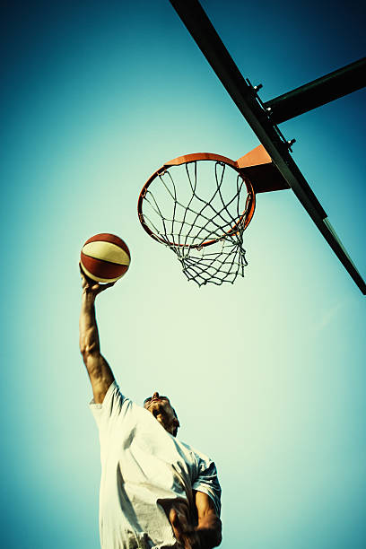 istock Basketball player slam dunking ball 453469587