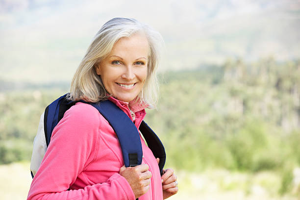 istock Senior woman in pink jacket carrying a backpack 453469651