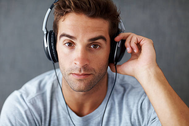istock Smart young guy listening to music on headphone 453471669