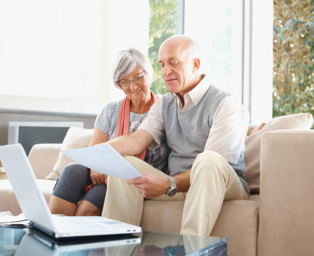 istock Senior couple with laptop reading a document at their house 453472649