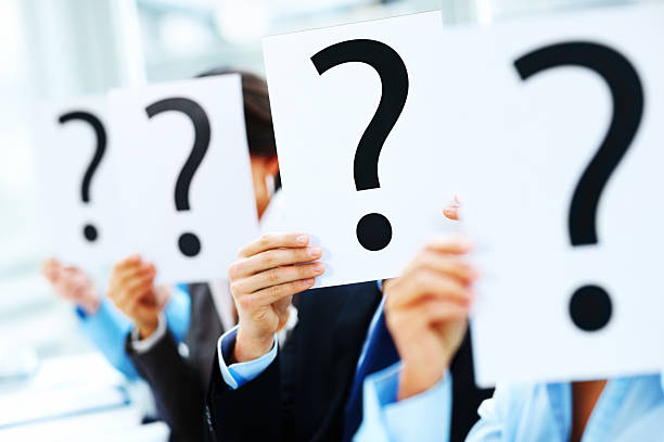 istock Closeup of colleagues holding question mark on boards 453473487