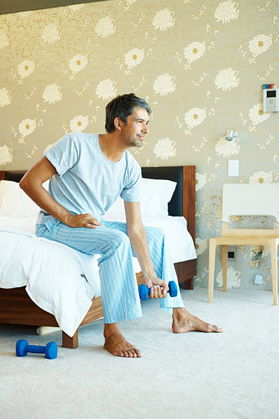 istock Mature man working out with dumbbells in his bedroom 453474077