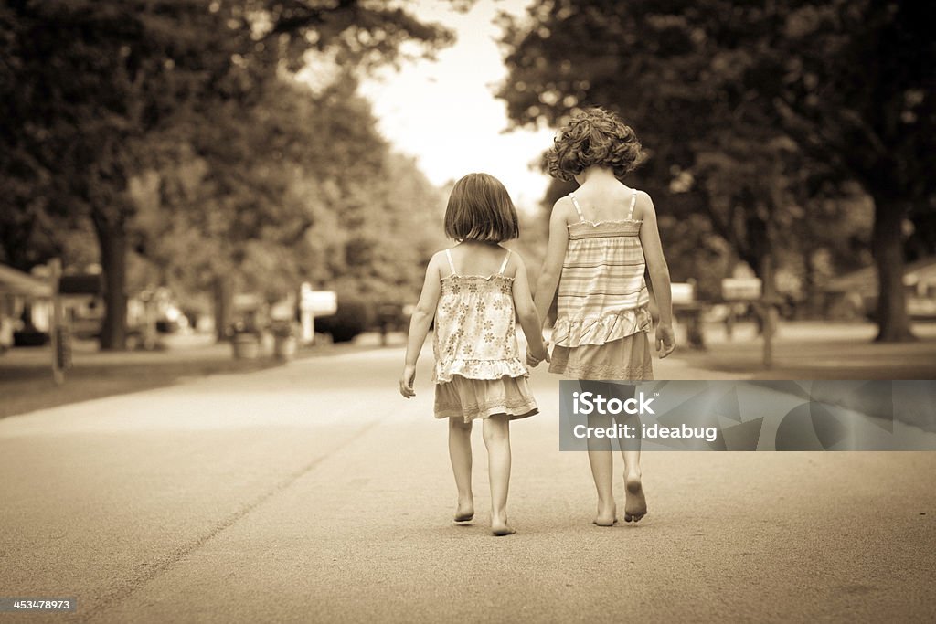 Sépia Portrait de deux heureux de marcher dans la rue Sisters - Photo de Petites filles libre de droits