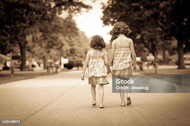 Photo libre de droit de Sépia Portrait De Deux Heureux De Marcher Dans La Rue Sisters banque d'images et plus d'images libres de droit de Petites filles