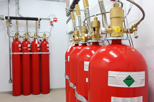 Some components of a gaseous fire suppression system. Canisters containing Heptafluoropropane (HFC227ea) gas for use in extinguishing fire in a public transportation network without damaging equipment. The items, which are connected to ventilation system of the network, are in stand-by position under control of a fire detection system.