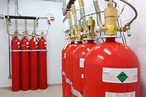 Close up of four fire extinguishers with four more behind stock photo