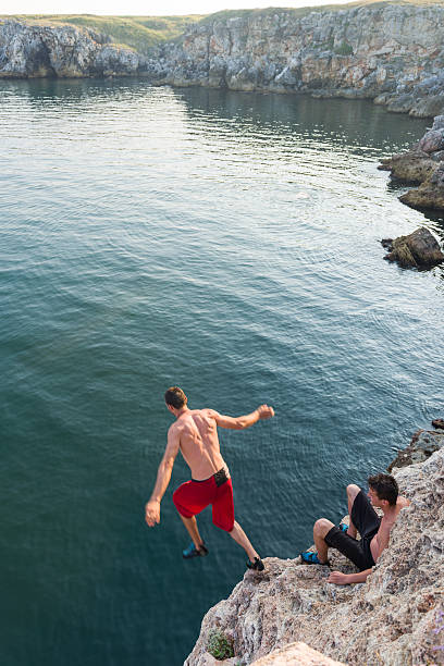 istock young man jumping in water 453484819