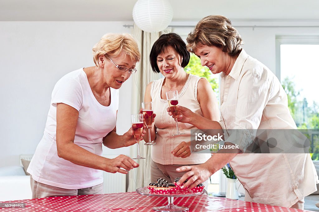 Senior party Three happy mature women celebrating with champagne. 55-59 Years Stock Photo