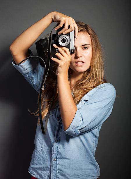 istock Photographer in jeans jacket taking pictures with old camera 453488009