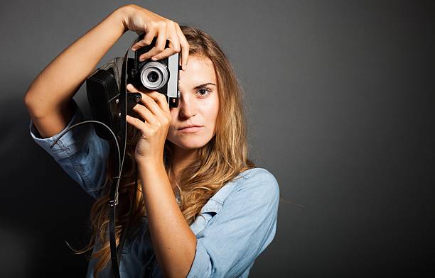 istock Photographer in jeans jacket taking pictures with old camera 453488031