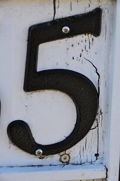 Street metal address black number 5 on white  with screws stock photo