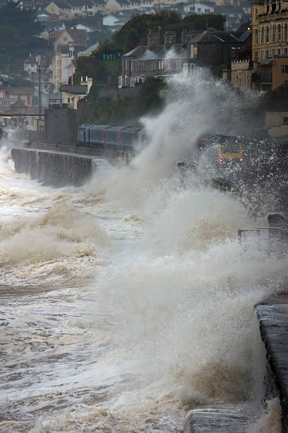 istock Waves breaking over train leaving Dawlish station in a storm 453489143