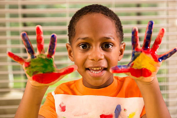 istock Back to School: Little boy finger painting in art class. 453489409