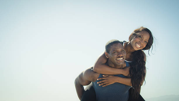 istock Young couple piggyback on the beach 453489599