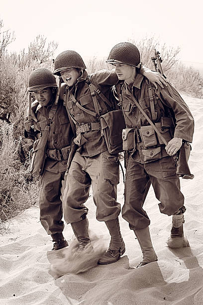 3 military WW2 in a combat zone A World War 2 American army soldier in the desert is shot and wounded by the enemy. Two of his comrades carry him away. Part 4 of combat action sequence. Authentic WW2 army uniforms. Vintage black and white photojournalism style. More vintage military photos. world war ii photos stock pictures, royalty-free photos & images