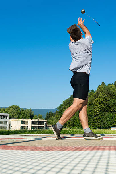 Young male athlete throwing the hammer