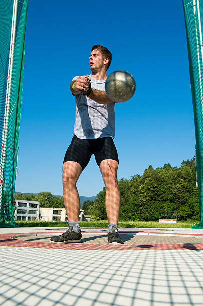 Young male athlete throwing the hammer