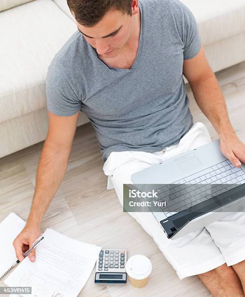 Ocupado Homem Sentado No Chão E Usando Um Computador Portátil - Fotografias de stock e mais imagens de Adulto