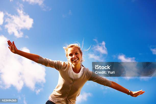 Female Spreading Her Arms Under The Open Blue Sky Stock Photo - Download Image Now - Spreading, Vacations, Blue