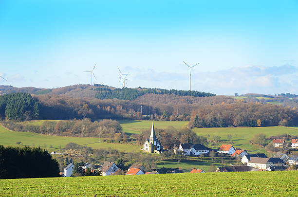istock Village in valley with wind turbines on hill at background 453495799