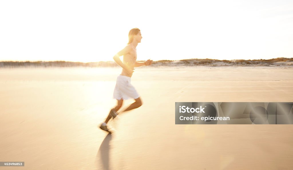 Maschio runner in corsa per la formazione al tramonto - Foto stock royalty-free di A petto nudo