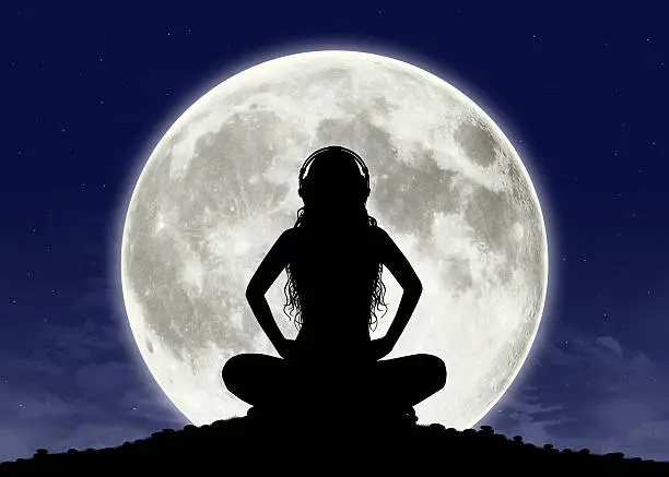 Photo of young woman listening to the music at full moon