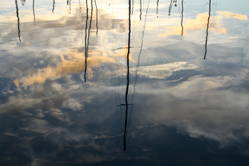 beautiful midnight reflections of boat masts in fjord waters, Norway