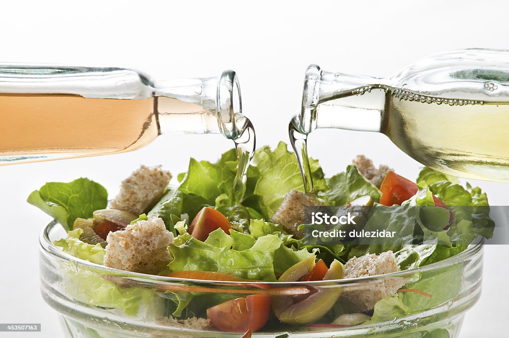 Salad Olive oil and vinegar pouring in to green salad Pouring Stock Photo