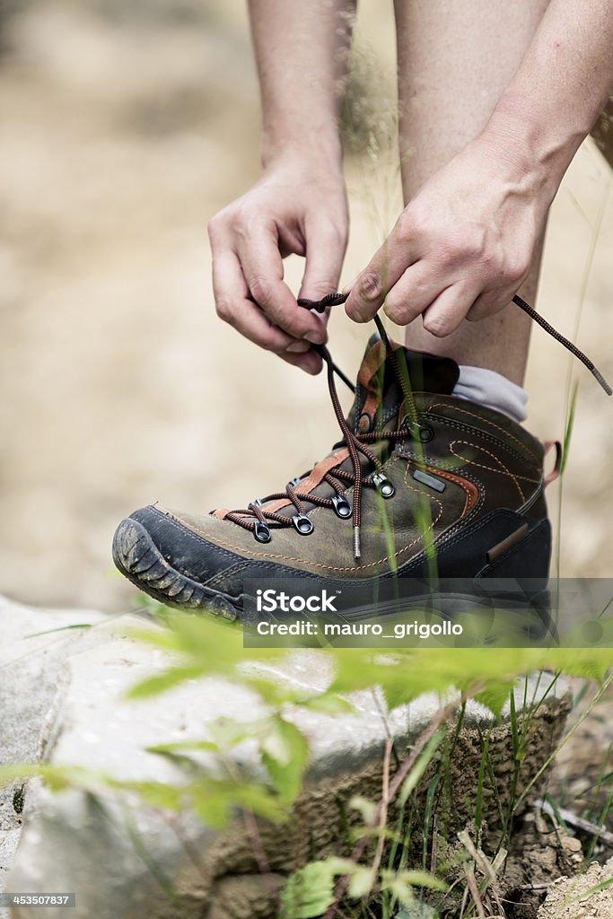 Female hiker tying boot laces Female hiker tying boot laces.  Outdoors Stock Photo