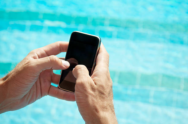 istock Hands Hold Blank Smartphone Mobile Phone at Swimming Pool 453511099