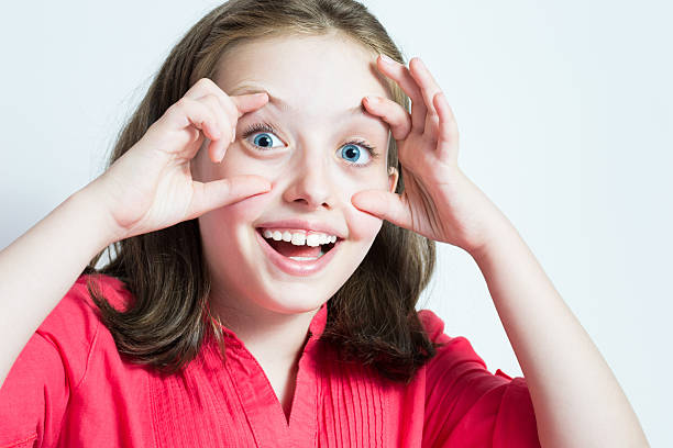 istock Beautiful young girl with eyes wide open 453511863