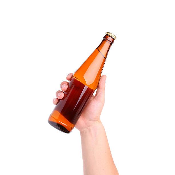 istock Beer bottle in the hand isolated on white 453511871
