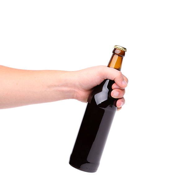 istock Beer bottle in the hand isolated on white 453511875