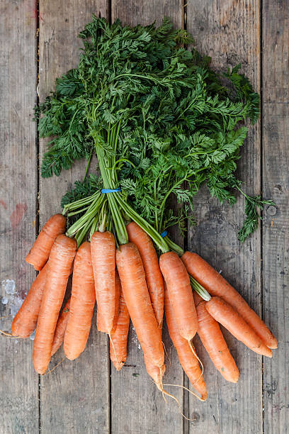 istock Freshly picked carrots on a wooden table 453515073