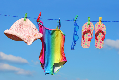 Summer holidays accessories hanging on clothesline against blue sky