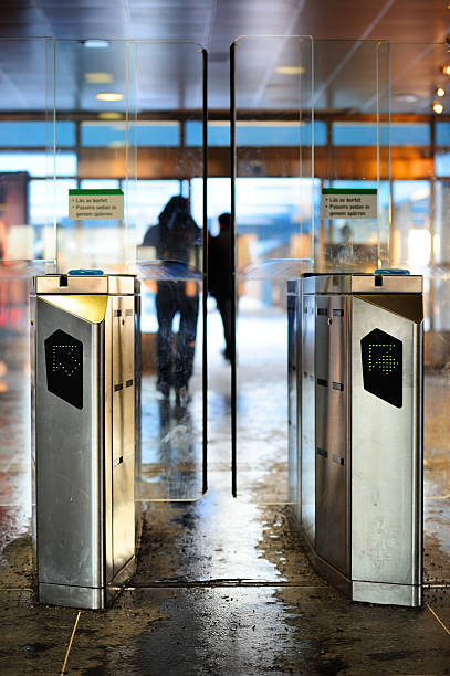 Subway station gate against bright background Motion blurred people out of focus walking through underground gates from the daylight of the street walking into glass door stock pictures, royalty-free photos & images