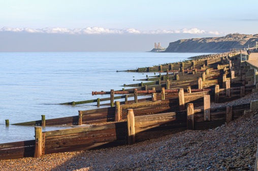 A striking strip of low cloud and a view of Reculver towers from Herne Bay, Kent, UK