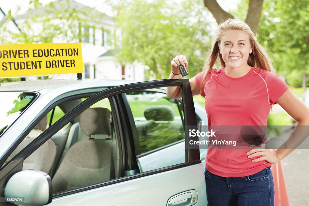 Teenage Driver Receive Key to Her First Car Subject: A happy young teen student driver receiving car key from parent. 16-17 Years Stock Photo