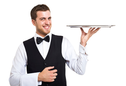 Smiling waiter holding an empty metal plate