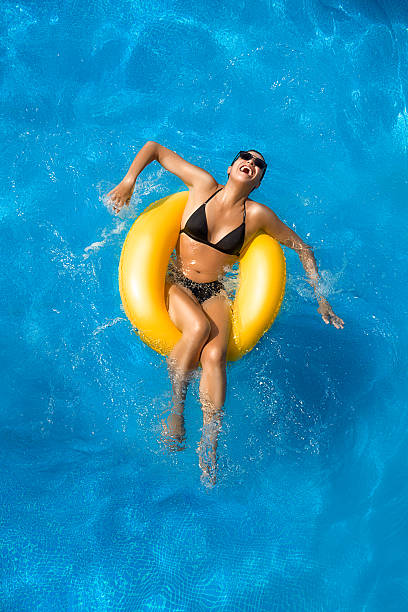 aquapark. spielen im pool - swimming pool women floating on water bikini stock-fotos und bilder